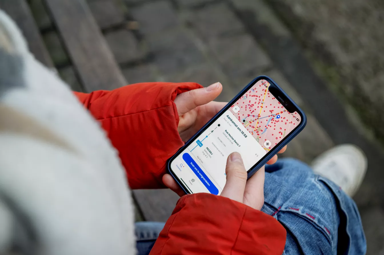Personne tenant son téléphone avec l'app Floya ouverte