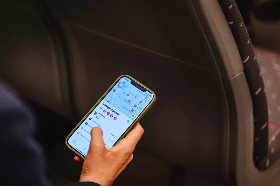 Person holding a smartphone on the train: close-up of the Floya ‘Public Transport’ screen